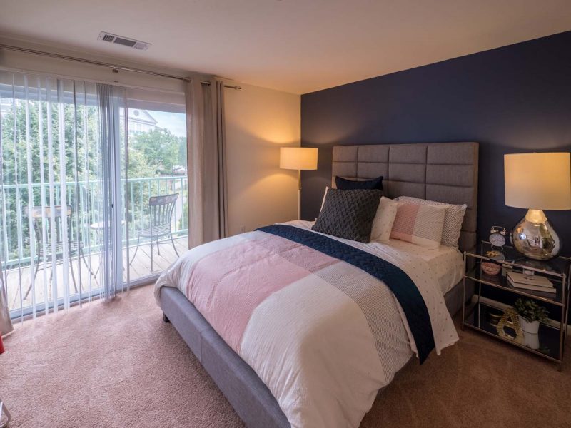 This image is a Premium Apartment Feature that displays the bedroom with a king-sized bed and balcony that overlooks the Harbor.